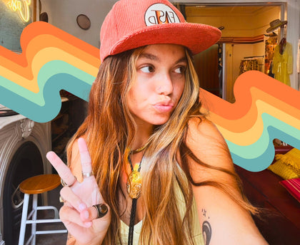 Cool girl with tattoos wearing an East and Up Flat bill corduroy hat, posing with a duck face and peace sign.