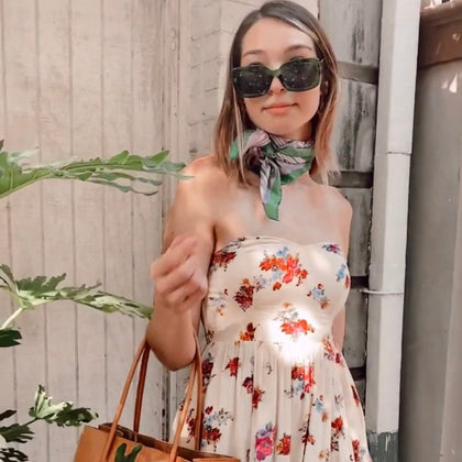 Cool girl with vintage silk scarf, big sunglasses and a beautiful floral dress.